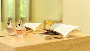 A wooden table with two perfume bottles and an open book. - Villa Orsalia With Private Pool (Rethymno)