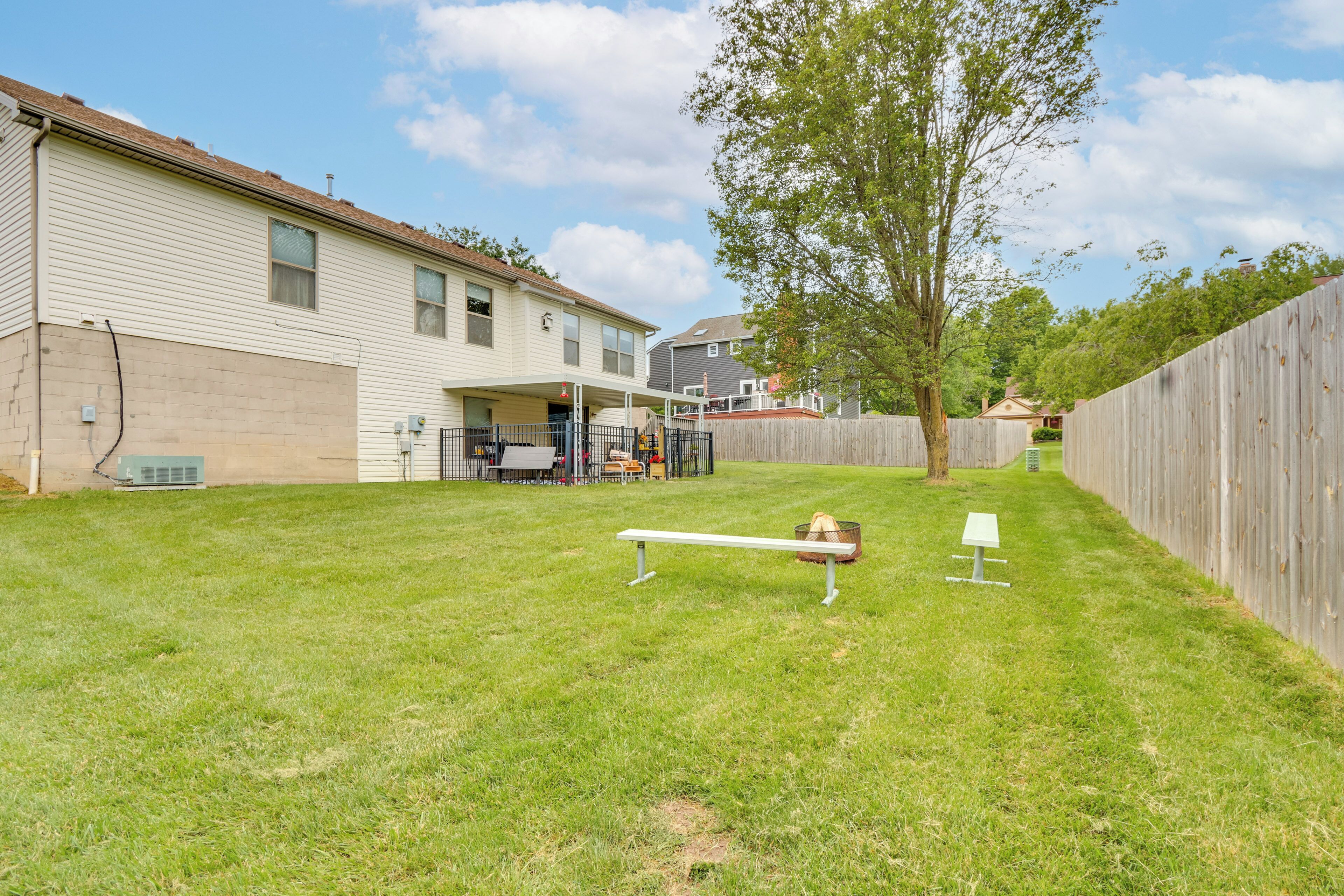 A backyard with a wooden deck, a swing set, and a picnic table.