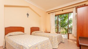 A room with two beds, a window with curtains, a small table, and a wooden wardrobe. - Kalkan Center 2+1 Villa in Nature - Variola (Antalya)