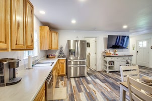 Una cocina moderna con armarios de madera, electrodomésticos de acero inoxidable y suelo estampado.