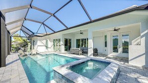 A swimming pool with a glass ceiling, a hot tub, and outdoor seating. - Luxury Marco Island Escape W/pool & Spa Retreat (Marco Island)