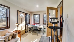 Una habitación con una cinta de correr, un escritorio y un sofá.