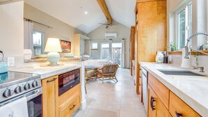 A spacious kitchen with wooden cabinets, a built-in oven, and a dining area with wicker chairs.