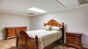 A bedroom with a wooden bed, a dresser, and a nightstand. - Executive Wfh-friendly Haven in Blythewood! (Blythewood)