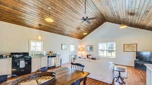 A spacious kitchen with wooden cabinets, a dining table, and a ceiling fan. - Countryside Barndominium in Virginia w/ Patio (Louisa)