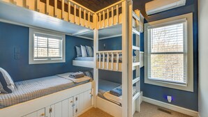 A bunk bed room with a window, built-in storage, and a ceiling fan. - Countryside Barndominium in Virginia w/ Patio (Louisa)