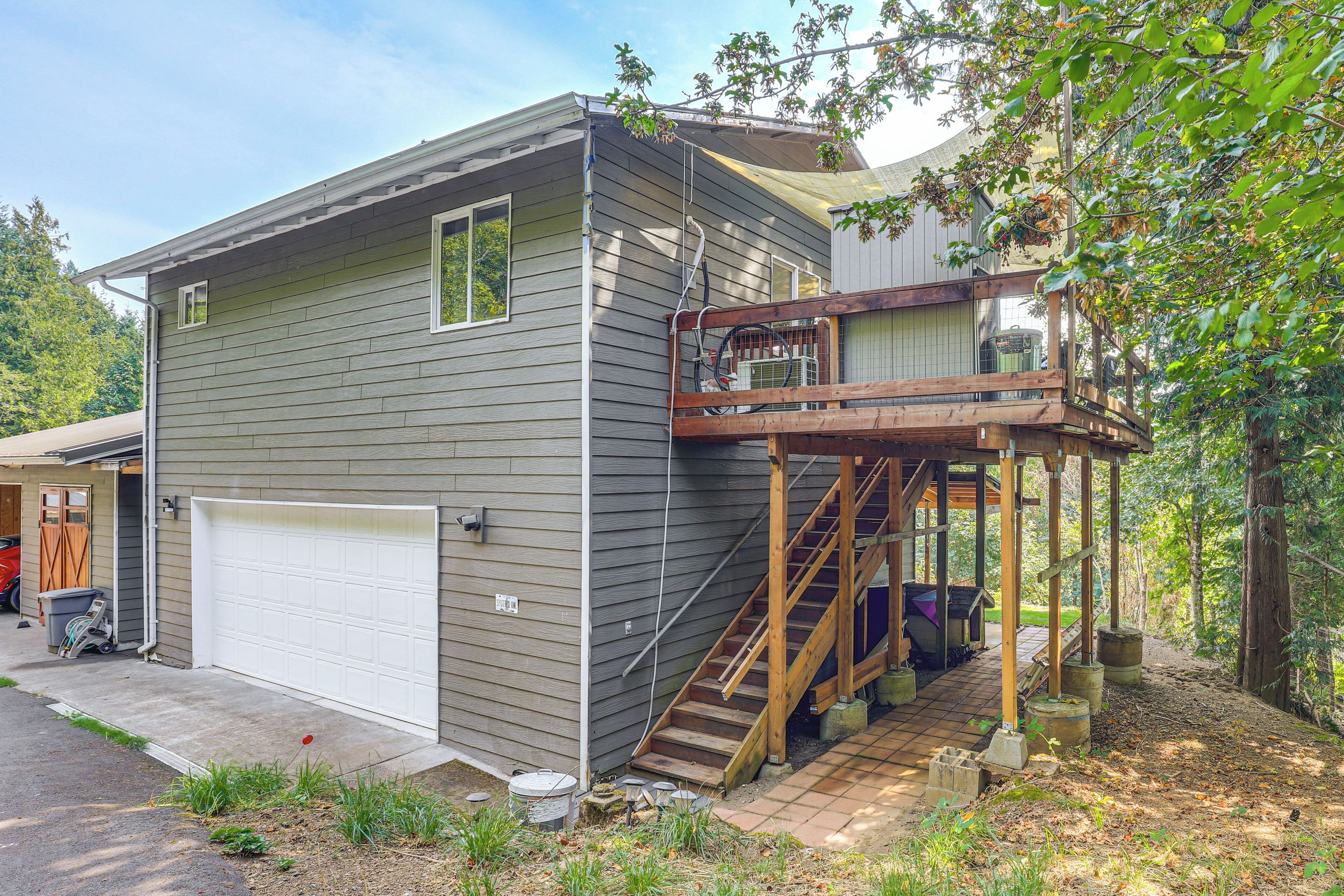 A two-story house with a wooden deck and a covered staircase.