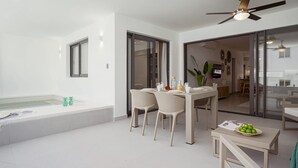 Un salon moderne avec un coin repas, un ventilateur de plafond et une vue sur la cuisine.