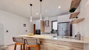 Een moderne keuken met een centraal eiland, roestvrijstalen apparatuur en houten details.