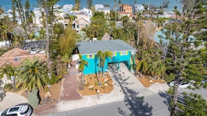 A coastal residential area with houses, a turquoise building, and a view of the ocean. - Sassy Seahorse: Heated pool, hot tub, ping pong, Foosball and pool table! (Anna Maria)