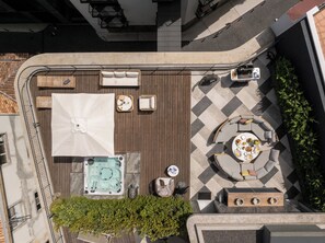 An outdoor patio with seating, a hot tub, and a dining area. - Luxury Rooftop Jacuzzi Penthouse at Savoy Insular (Funchal)