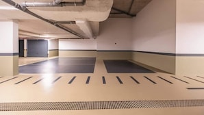 An empty parking garage with concrete floors, metal pipes, and a green ceiling. - Luxury Rooftop Jacuzzi Penthouse at Savoy Insular (Funchal)