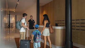 A hotel lobby with a reception desk, wooden paneling, and a luggage trolley. - Luxury Rooftop Jacuzzi Penthouse at Savoy Insular (Funchal)