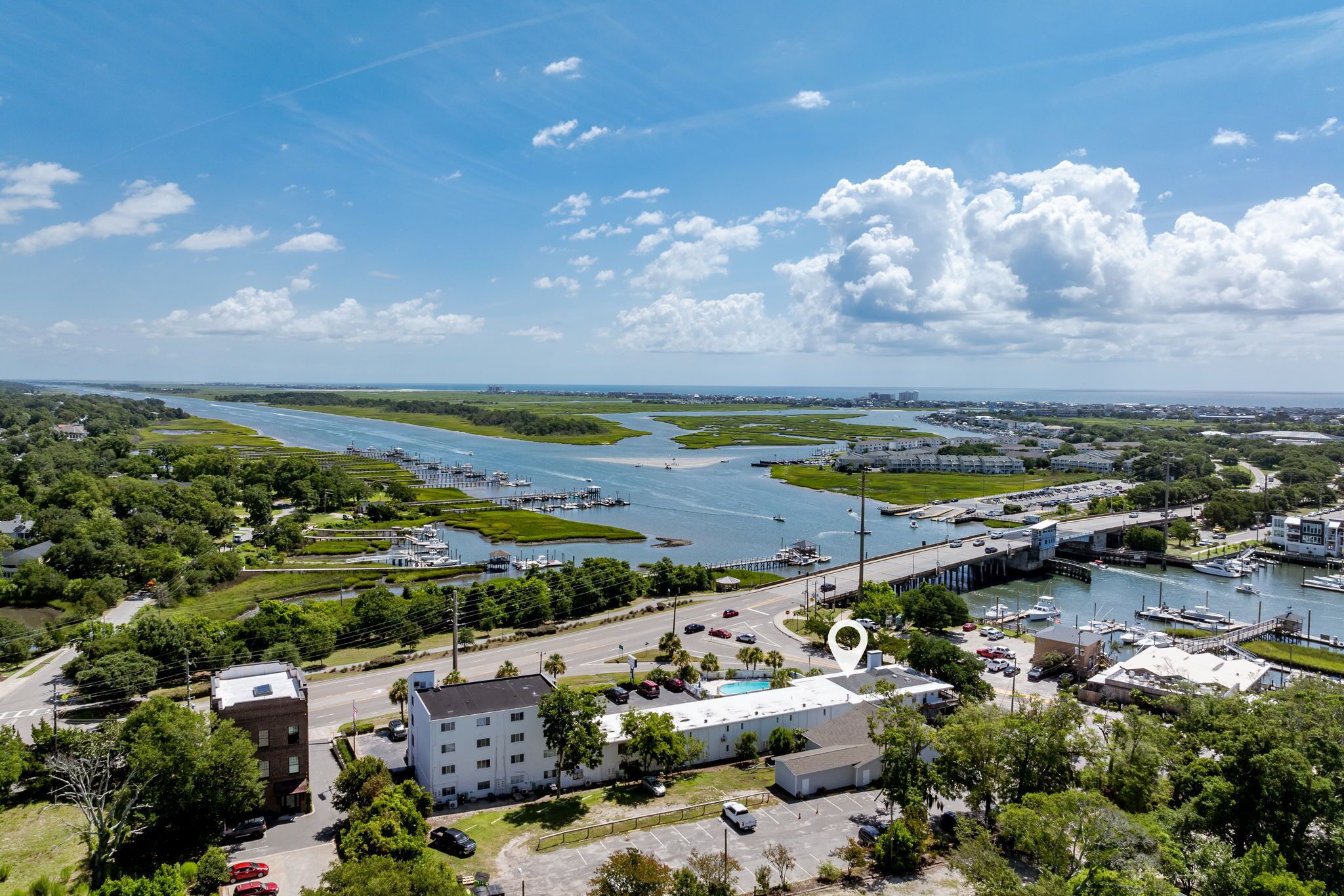 An aerial view of a coastal area with a marina, a bridge, and a river.