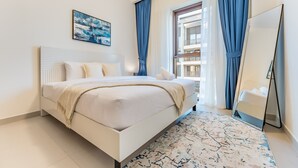 Una habitación de hotel moderna con una cama grande, un cuadro en la pared y vistas del edificio exterior.
