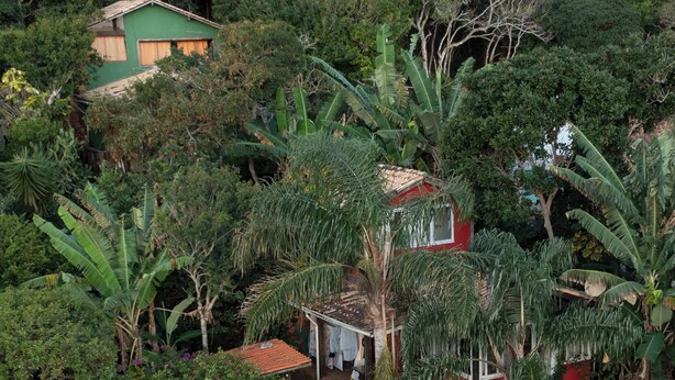 A residential property with a swimming pool, a staircase leading to a red-roofed house, and lush vegetation. - Casamata (Búzios)