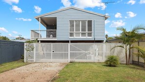 A two-story house with a balcony, a fenced yard, and a clear sky. - Cerulean Getaway in Cowes (Cowes)