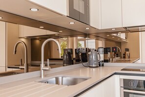 A modern kitchen with stainless steel appliances, a built-in oven, and a large window providing natural light. - Luxury 2 Bedroom, 2 Bathroom Apartment - Oxford (Oxford)