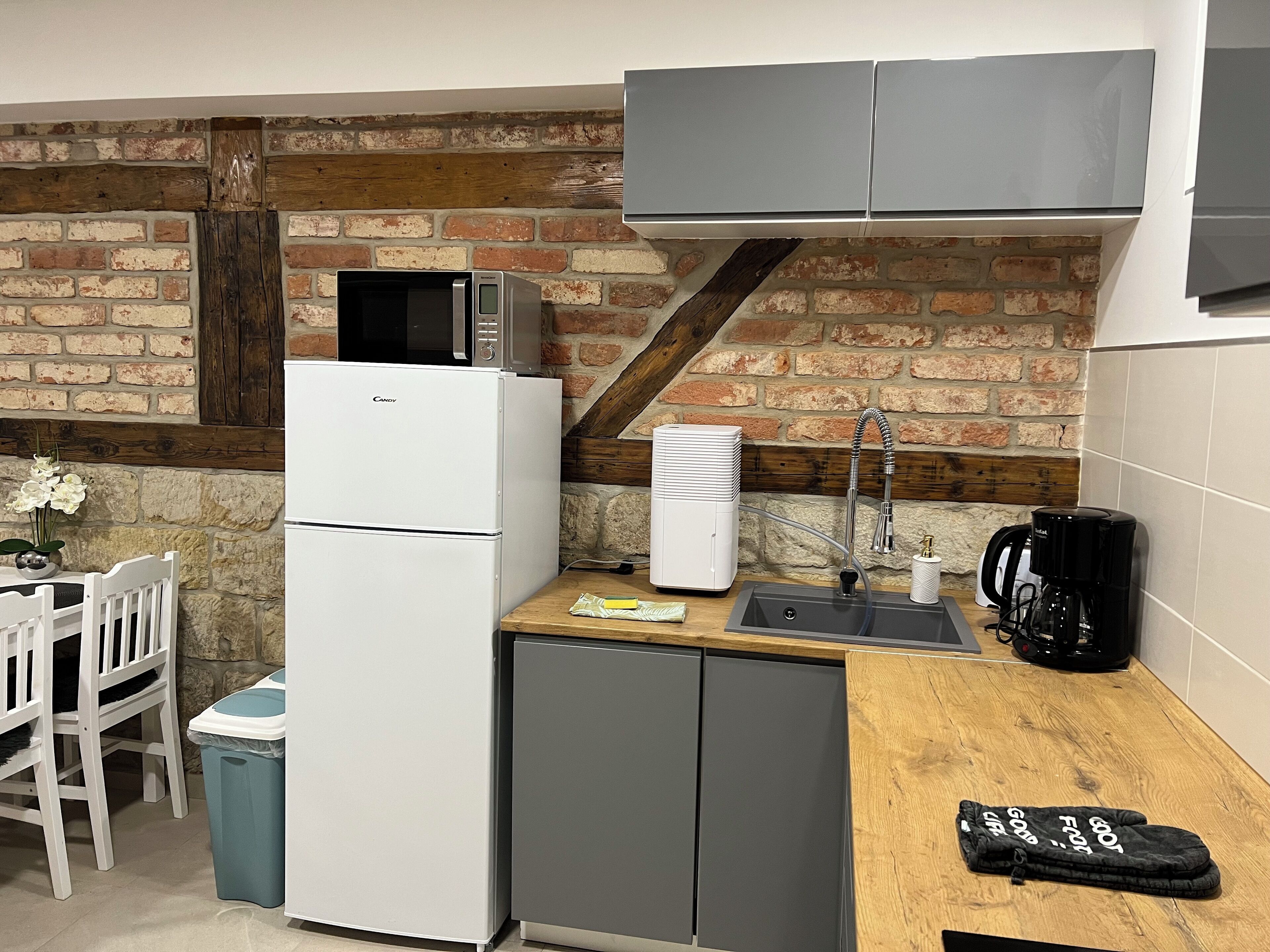 Una cocina compacta equipada con refrigerador, microondas, lavaplatos y cafetera.