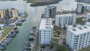 Un puerto deportivo con barcos amarrados, rodeado de edificios altos con balcones con vistas al agua.