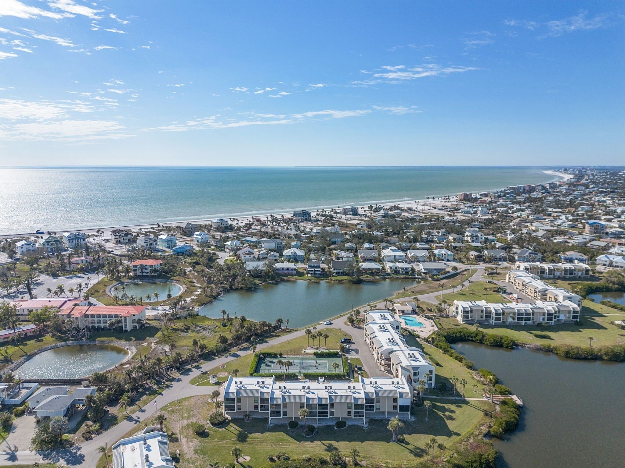 A coastal residential area with a large body of water, a beach, and a marina.