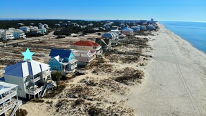 A coastal residential area with beachfront properties featuring balconies and ocean views. - Beachfront Duplex in Morgantown (Gulf Shores)
