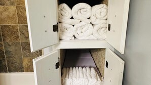 Ein Badezimmer mit Handtuchhalter, auf dem ordentlich gerollte Handtücher liegen.