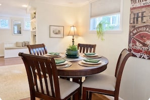 A dining area with a round table, four chairs, a lamp, and a potted plant. - Capitol Hill Charm + Walk to Union Station + Free Parking (Washington)
