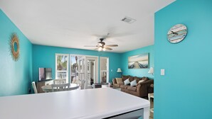 A kitchen with a white countertop, a ceiling fan, and a clock on the wall. - New Listing! Beach Vibe Is Only A Boardwalk Away From The Gulf! (Pensacola)