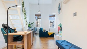 Un espacio habitable moderno con un escritorio de madera, un sofá azul y un banco azul.