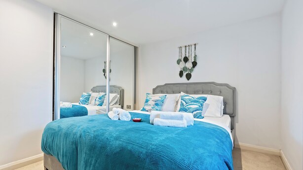 Un dormitorio con una cama grande, una puerta corrediza de vidrio y un adorno en la pared.