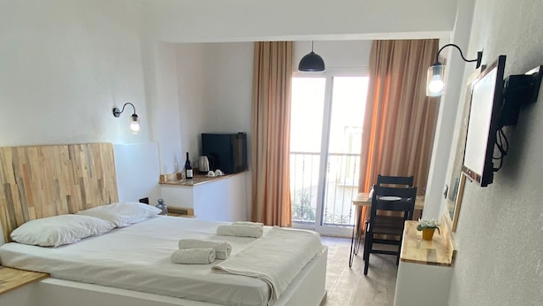 A modern hotel room with a large bed, a desk, a TV, and a balcony with curtains. - Comfort Room -A- (Marmaris)