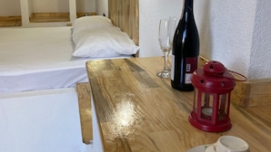 A hotel room with a wooden bed, a bedside table with a wine bottle, glasses, a red lantern, and a cup on a saucer. - Comfort Room -A- (Marmaris)
