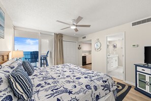 Ein Schlafzimmer mit Bett, Deckenventilator, Bad und Blick zum Himmel.