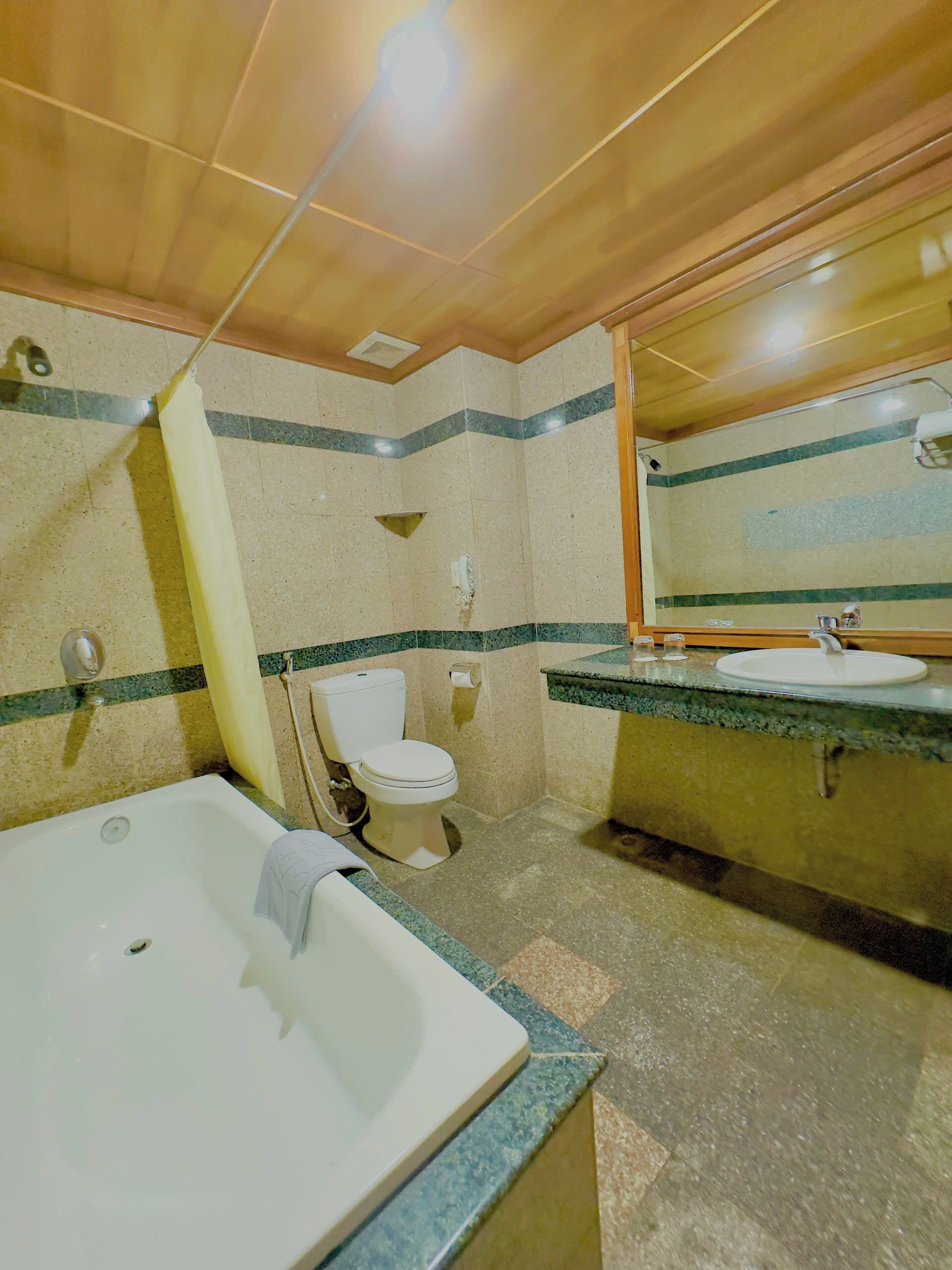 Een badkamer met een bad, toilet en wastafel.