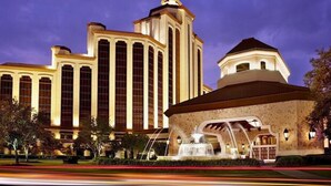Un hotel grande con una torre destacada y una fuente.