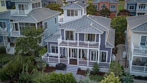 A two-story house with a balcony, a porch, and a small garden area. - Everyday Your Beachside Escape! (Cape Charles)