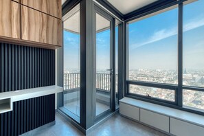 A modern interior with a large window, a built-in bench, and a wooden cabinet.