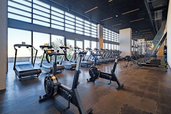 A gym with treadmills, stationary bikes, and rowing machines.