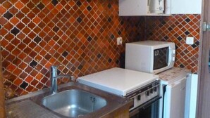 A compact kitchen with a sink, a microwave, a stove, and a small refrigerator. - 50m from resort center, 4th floor, balcony, 24m², Le Grand Bornand (Le Grand-Bornand)