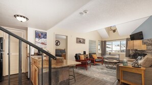 A spacious living area with a kitchen, a dining area, and a view of a snowy landscape. - Wonderful 2 bedroom, pet friendly, ski-in/ski-out (Granby)