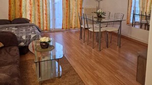 A living room with a sofa, coffee table, and dining area with chairs and a table. - Le Grand Robinson, 6 minutes from RER B Robinson, ideal for families. (Le Plessis-Robinson)