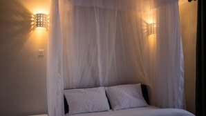Ein Bett mit Baldachin, zwei Wandleuchten und eine Steckdose an der Wand.