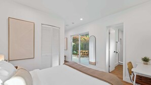 A modern bedroom with a large bed, a desk, and a view of the outdoors. - Modern Clean Studio Apartment Near Beach (Fort Lauderdale)