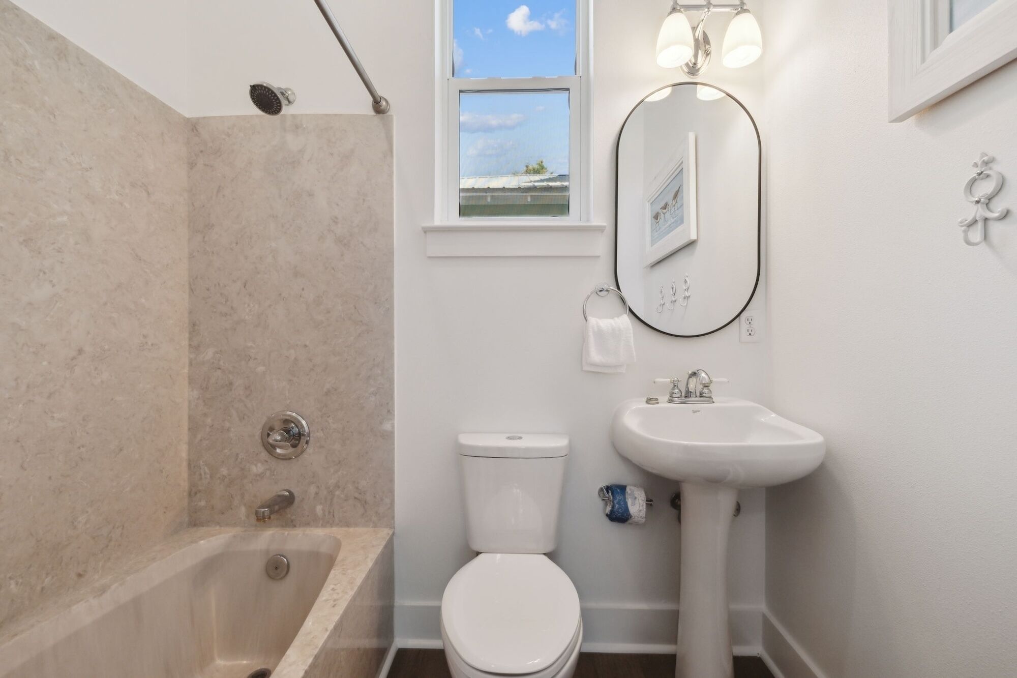 A bathroom with a bathtub, toilet, and sink.