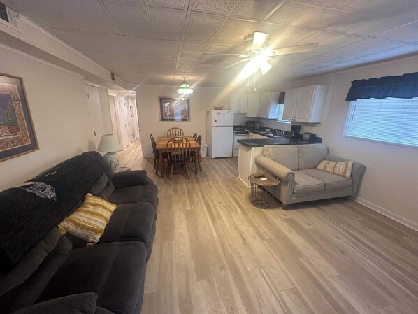 A compact living space with a dining area, kitchenette, and seating area.
