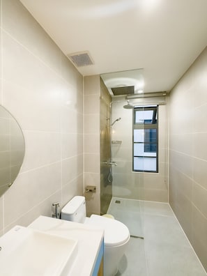 A modern bathroom with a glass shower enclosure, a toilet, and a sink. - Deluxe 4 Br Warm Villa - Novaworld PT (Tien Thanh)