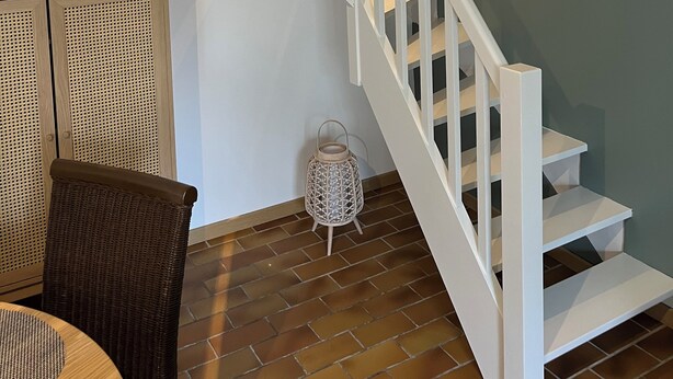 A staircase with white railings and a light fixture above it.