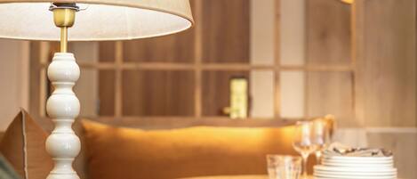 A room with a round table, a sofa, and a lamp.