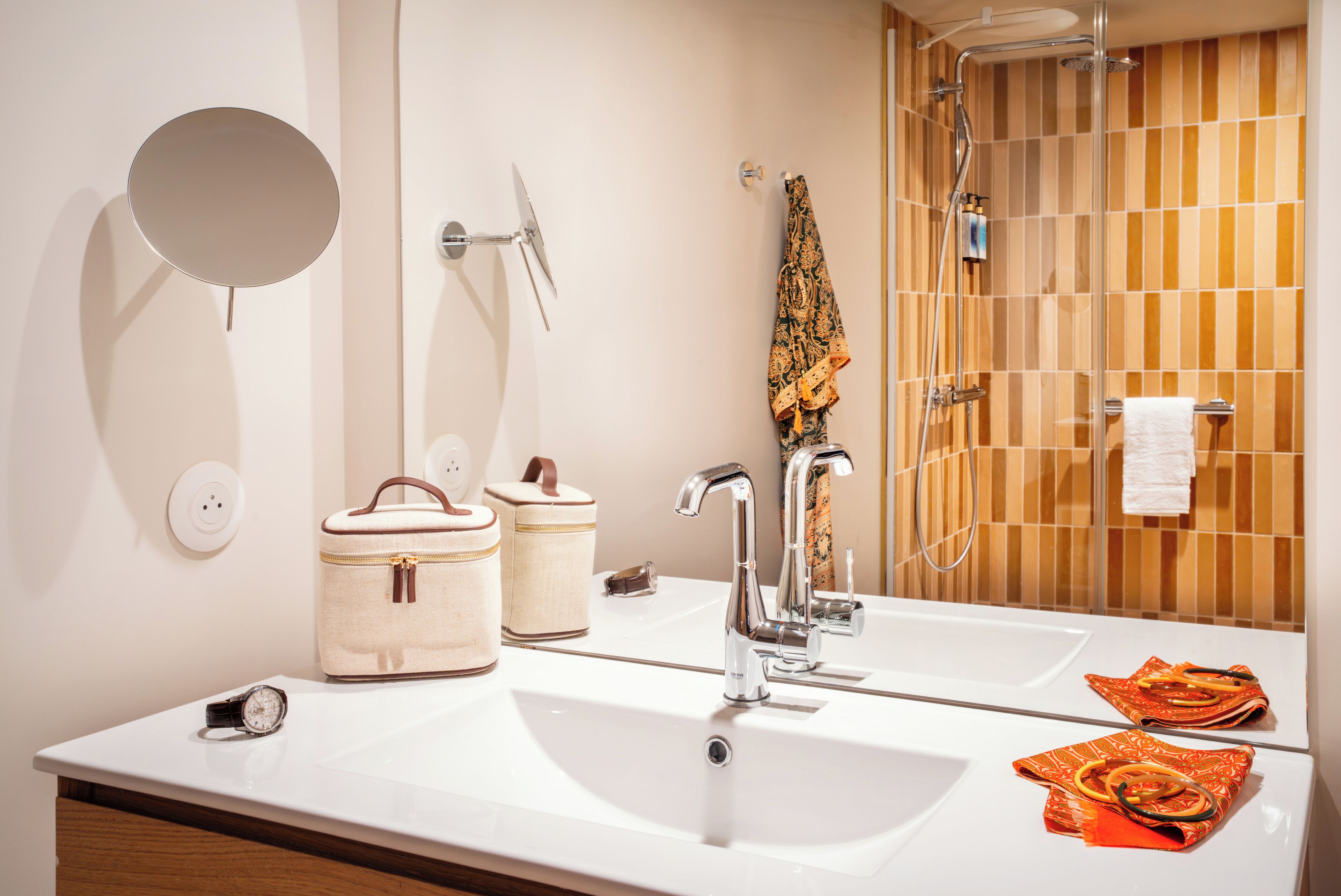 Un baño con lavamanos blanco, espejo, toallero y ducha.